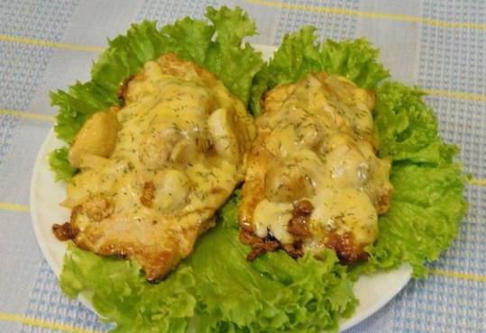 Schweinekoteletts in einer Pfanne mit Pilzen