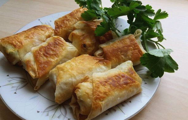 Lavash-Umschläge mit Hüttenkäse und Kräutern in einer Pfanne