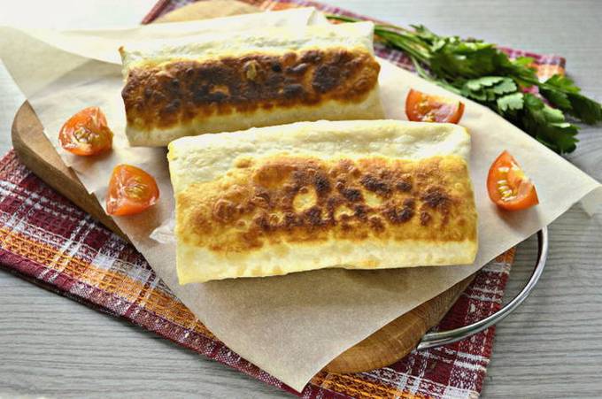 In dünnem Fladenbrot gerollte Wurst in einer Pfanne