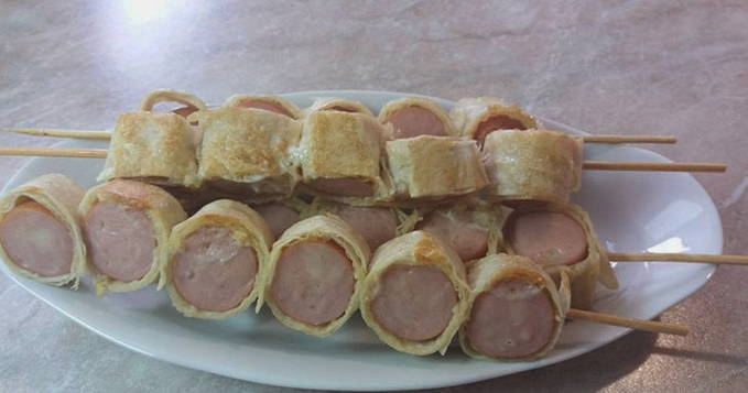 Worstjes in pitabroodje met kaas op spiesjes in een pan