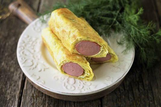 Würstchen in Fladenbrot mit Käse in einer Pfanne