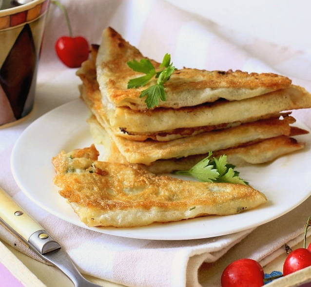 Lavash-Dreiecke mit Hüttenkäse und Kräutern in einer Pfanne