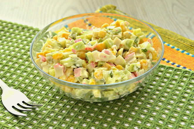 Insalata con bastoncini di granchio, mais, cetriolo e crostini