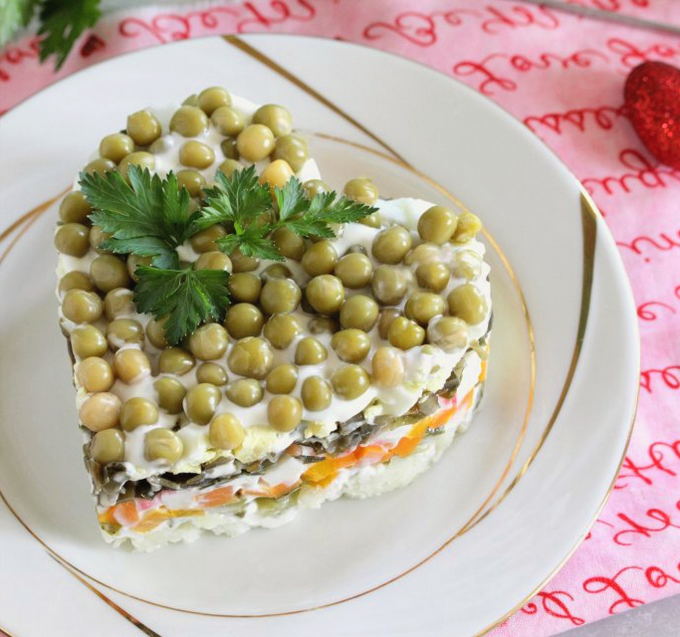 Salat mit Krabbenstäbchen, Gurke, Ei und grünen Erbsen