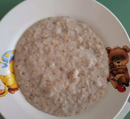 Weizenbrei mit Milch in einem Topf auf dem Herd