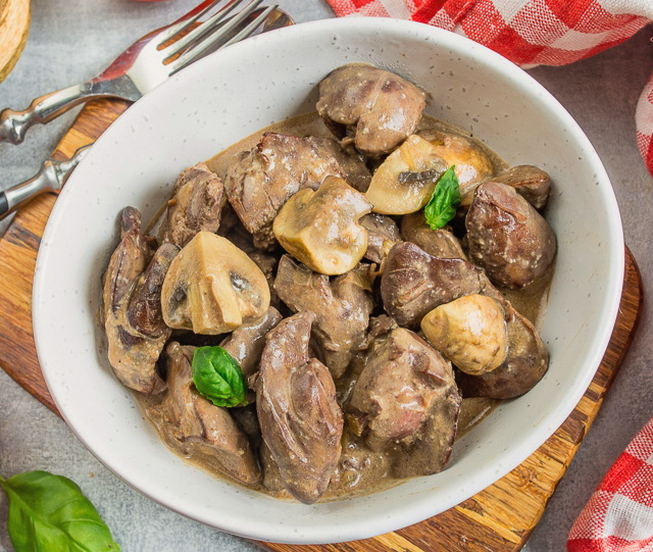 Hühnerleber mit Zwiebeln und Champignons in einer Pfanne