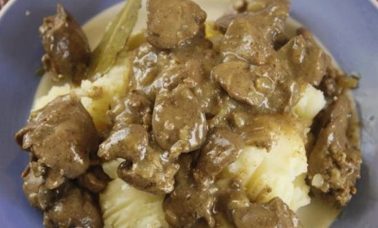 Hühnerleber in Mehl mit Zwiebeln in einer Pfanne