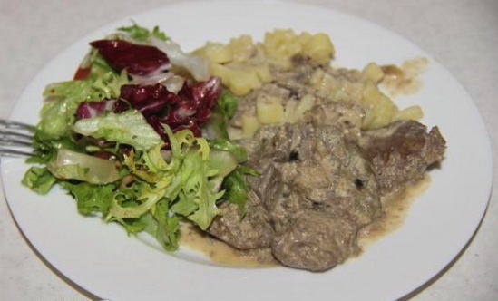 Kycklinglever med lök och gräddsås i en kastrull
