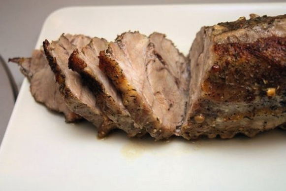Ganzes Stück Schweinefleisch mit Knoblauch in Folie im Ofen