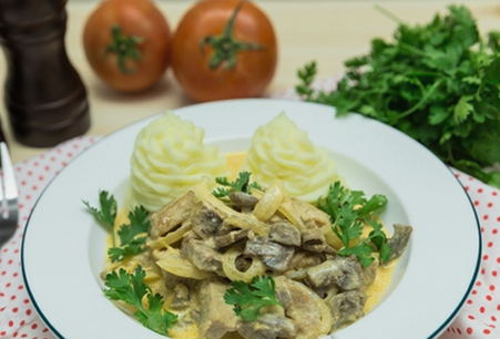 Schweinefleischstücke mit Pilzen in einer Pfanne