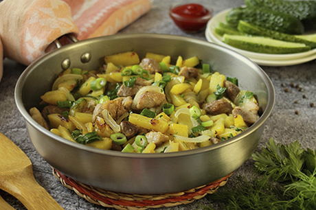 Schweinefleischstücke mit Kartoffeln in einer Pfanne