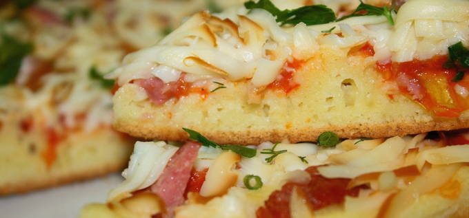 Pizza med pølse, ost og tomater i en gryde
