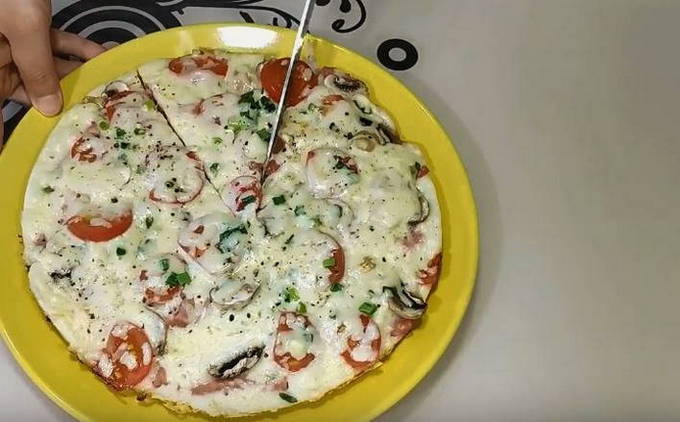 Pizza in einer Pfanne mit Pilzen und Wurst